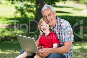 Happy father using laptop with his son