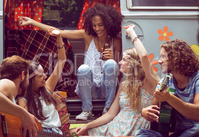 Hipster friends by camper van at festival