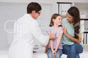 Doctor examining little girl with her mother