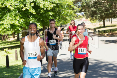 Happy people running race in park