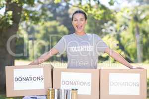 Pretty volunteer with donation boxes in park