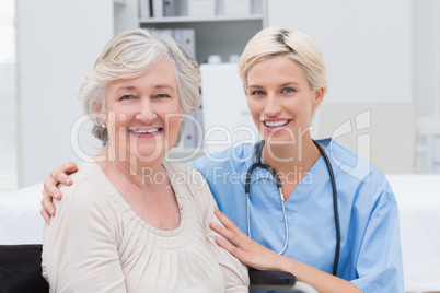 Nurse with arm around senior patient in clinic