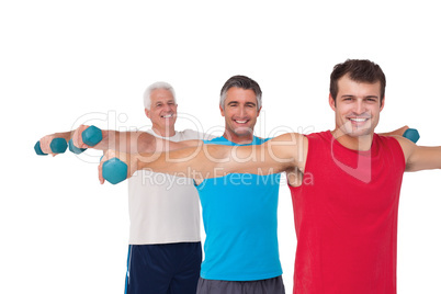 Fit men lifting dumbbells together