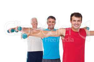 Fit men lifting dumbbells together