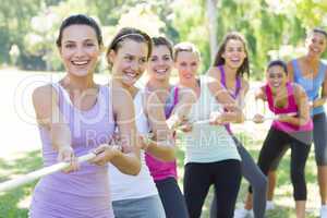 Fitness group playing tug of war