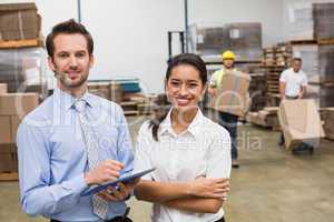 Smiling warehouse managers working together