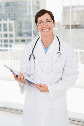 Smiling veterinarian holding clipboard