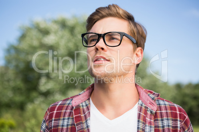 Handsome hipster thinking in the park