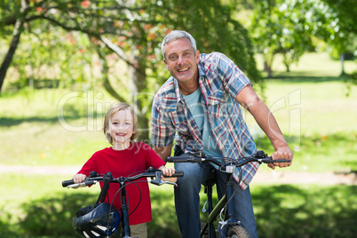 Happy father on a bike with his son