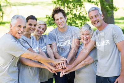 Happy volunteer family putting their hands together