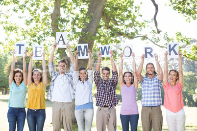 Friends holding teamwork signs in the park