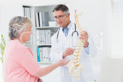 Doctor and patient having discussion over anatomical spine