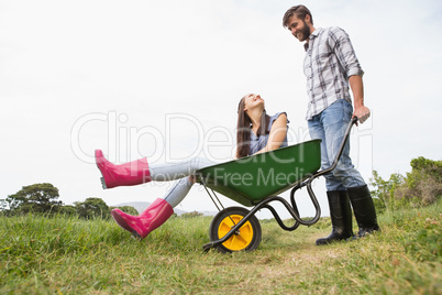 Man pushing his girlfriend in a wheelbarrow