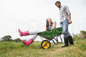 Man pushing his girlfriend in a wheelbarrow