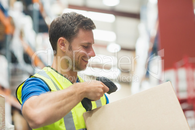 Smiling manual worker scanning package