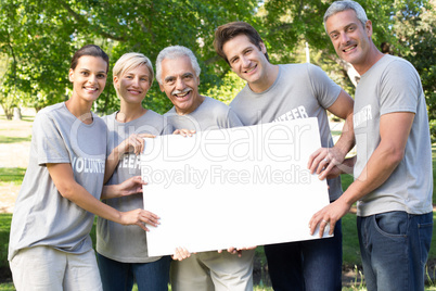 Happy volunteer family holding a blank