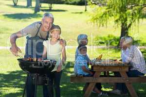 Happy father doing barbecue with his daughter