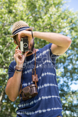 Handsome hipster using vintage camera