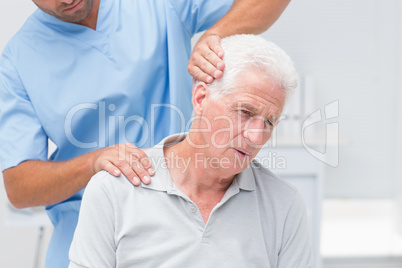 Physiotherapist giving physical therapy to senior patient