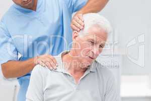 Physiotherapist giving physical therapy to senior patient