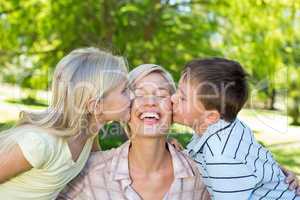 Sister and brother kissing their mother