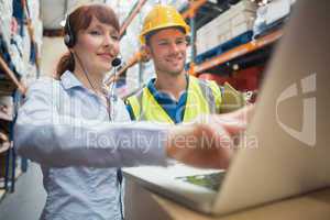 Smiling businesswoman wearing headset using laptop