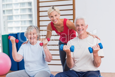 Happy female trainer with senior couple