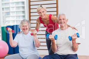 Happy female trainer with senior couple