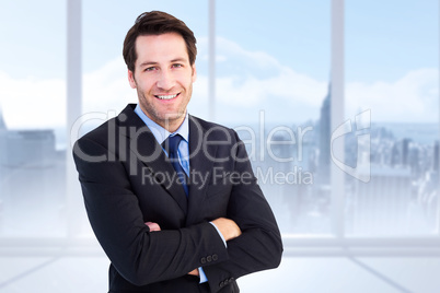 Composite image of smiling businessman with arms crossed