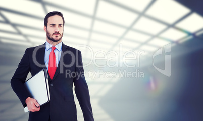 Composite image of handsome businessman holding briefcase and la