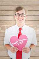 Composite image of geeky hipster holding heart card