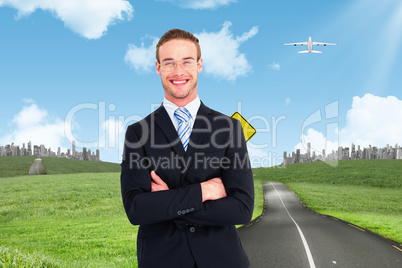 Composite image of smiling businessman in suit with arms crossed