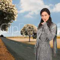 Composite image of young model with winter clothes keeping secre