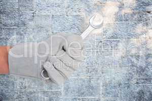 Composite image of mechanic holding spanners on white background