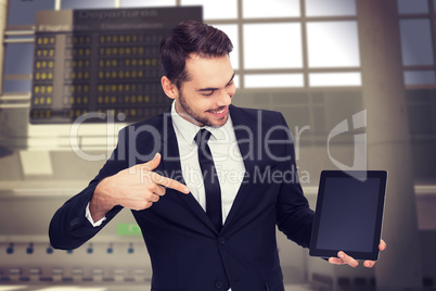 Composite image of happy businessman pointing with his tablet