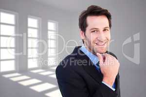 Composite image of businessman touching his chin while smiling a
