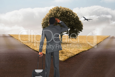 Composite image of young businessman standing with suitcase