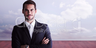 Composite image of smiling businessman posing with arms crossed