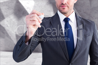 Composite image of serious businessman writing with marker