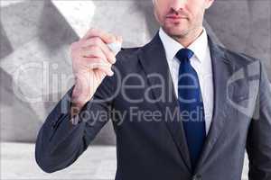 Composite image of serious businessman writing with marker