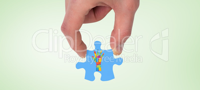 Composite image of hand holding jigsaw piece