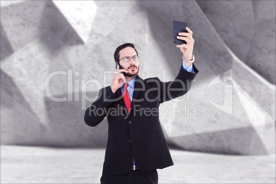 Composite image of businessman holding calculator while talking