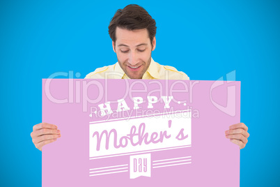 Composite image of attractive man smiling and holding poster