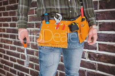 Composite image of manual worker holding hammer