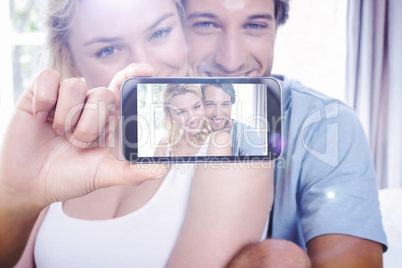 Composite image of hand holding smartphone showing Composite image of hand holding smartphone showing