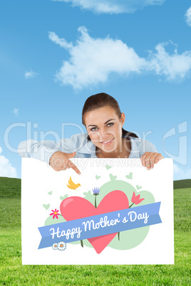 Composite image of businesswoman pointing on sign under her