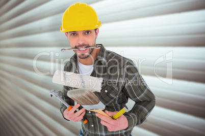 Composite image of manual worker holding various tools