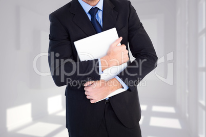 Composite image of smiling businessman holding his laptop lookin