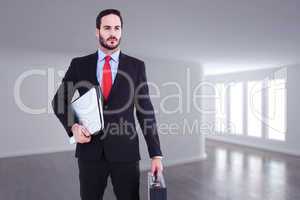 Composite image of handsome businessman holding briefcase and la