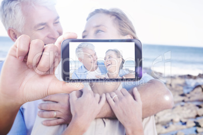 Composite image of hand holding smartphone showing